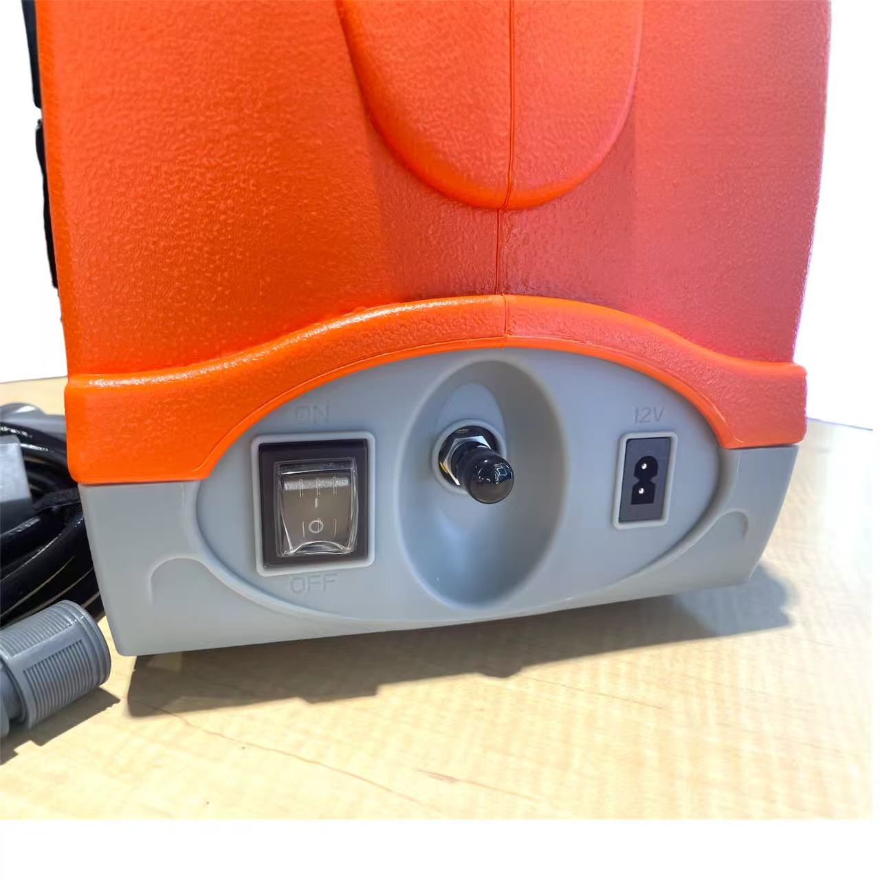 12V portable orange pressure washer cleaning an outdoor air conditioner unit with 15L water tank and adjustable spray gun