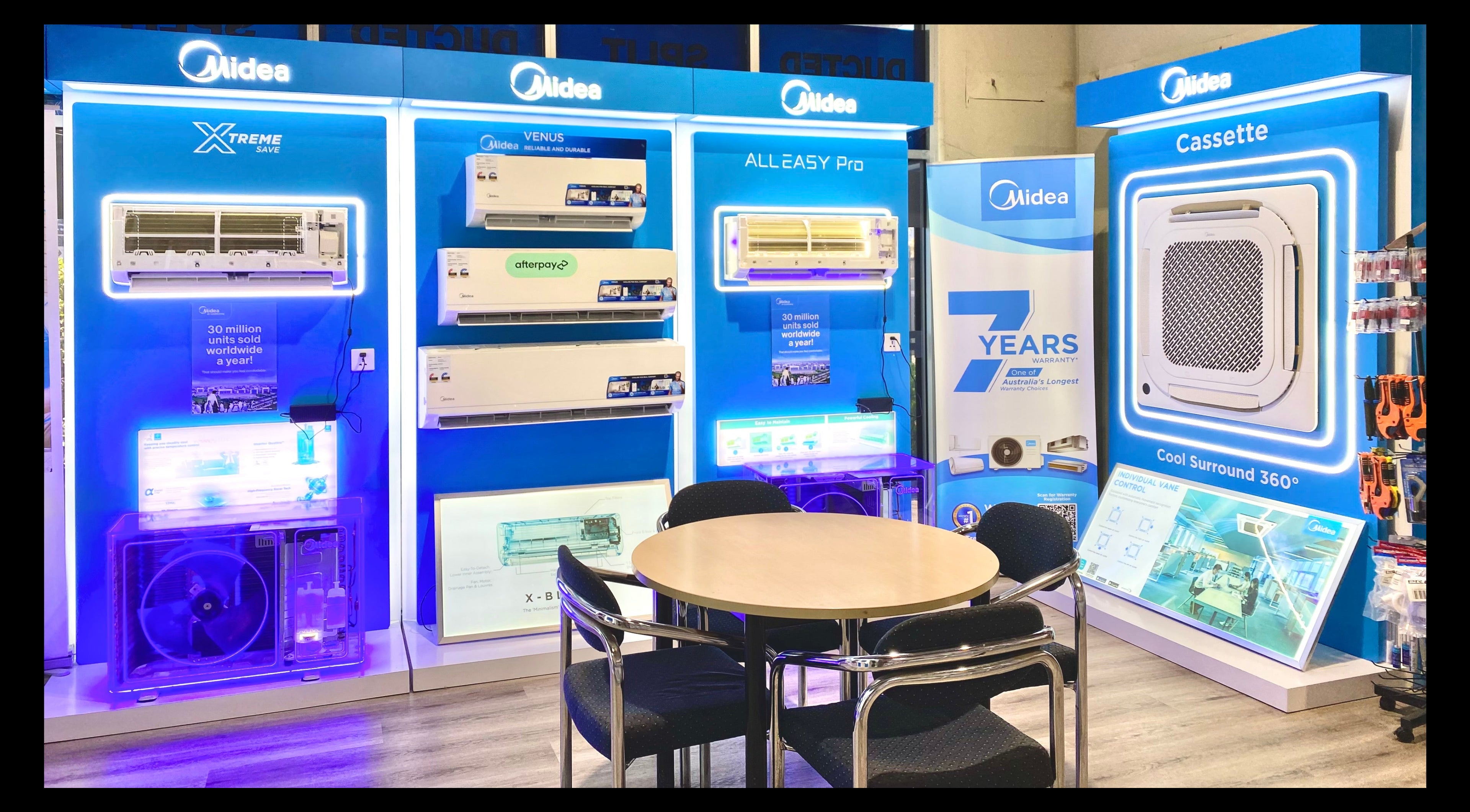 Midea air conditioner display with promotional materials in a showroom setting.